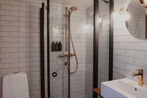 a bathroom with a shower with a toilet and a sink at Home Hotel Packhuset in Kalmar