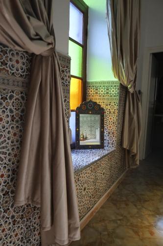 specchio in una stanza con finestra di Riad Dar Al Fassia a Oujda