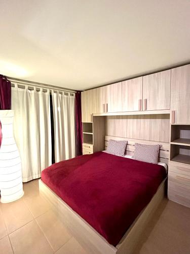 a bedroom with a large bed with a red blanket at Leo Loft - Pool, Sauna & Free Parking in San Bernardino