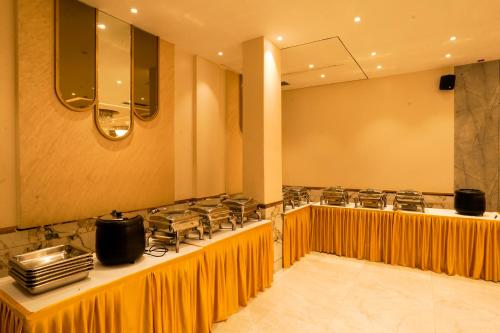 a row of counters in a restaurant with mustard curtains at The Food Villa in Jāmb