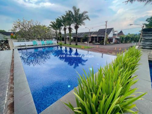 una piscina en una villa de agua azul en Ivo Homestay Jogja, en Gondowulung