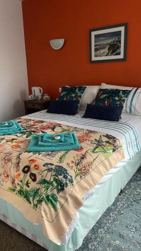 a bed with a colorful blanket on top of it at Le Diamant Chambrés in Mauprévoir