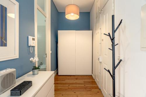 a bathroom with blue walls and a white closet at Downtown Riverside by Homing in Lisbon