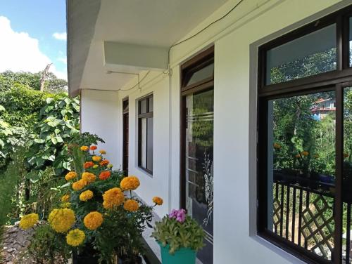 Un balcón con flores al costado de una casa. en Hridhaan Hometay, en Kalimpong