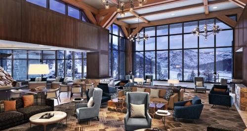 eine große Lobby mit Sofas, Stühlen und Fenstern in der Unterkunft Remodeled Second Floor Valley View suite in Olympic Valley