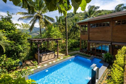 eine Villa mit Swimmingpool und ein Haus in der Unterkunft amã Stays & Trails The Malabar Villa Heliconia, Kozhikode in Wayanad
