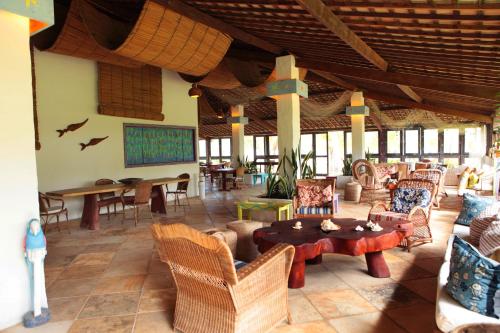 a living room with chairs and tables in a resort at Pousada Borapirá in Tatuamunha