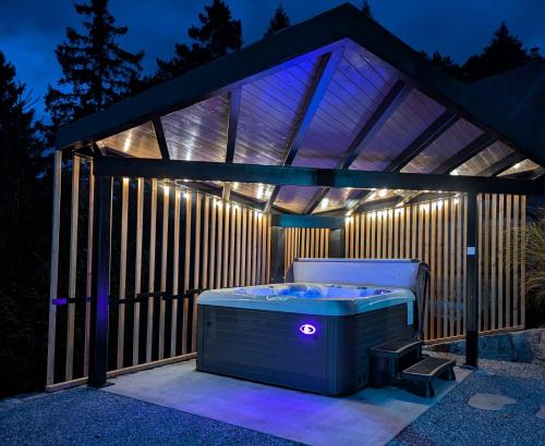 a hot tub in a gazebo at night at Pine Hill RUBY with free jacuzzi in Rakitna