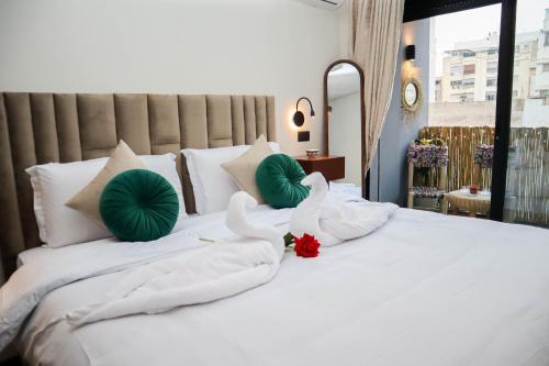 two swans are sitting on a white bed at R108- Gorgeous & Cosy Aprt with Wifi, Parking and Gym at the heart of Bourgogne in Casablanca-Port