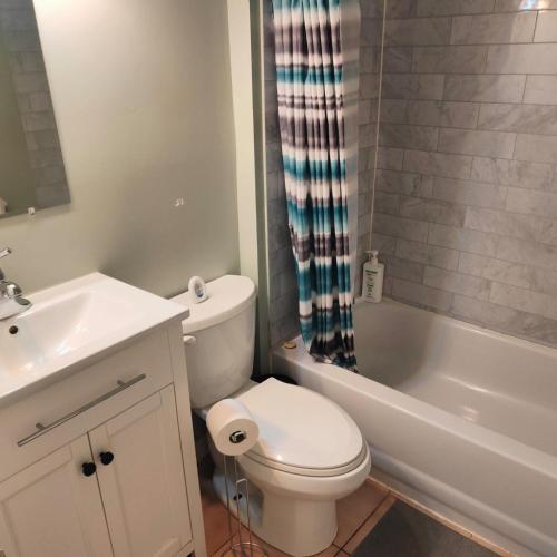 a white bathroom with a toilet and a sink at Full Downtown Access-Central Location-Self Checkin in Toronto