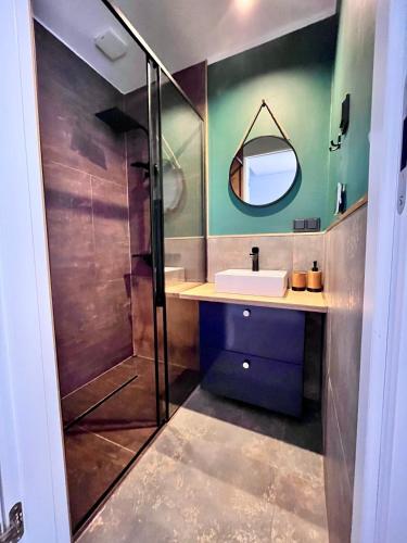 a bathroom with a shower and a sink and a mirror at Touareg House in Szczyrk