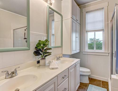 a white bathroom with two sinks and a toilet at North Beach Outlook in Tybee Island