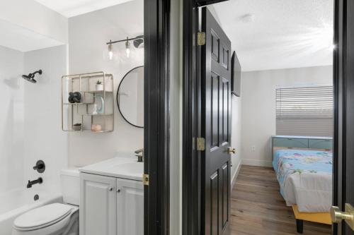 a bathroom with a sink and a toilet and a bed at Lux 6br5ba, Htd Pool, Hot Tub, Game Rm Sleeps 22 in West Bradenton
