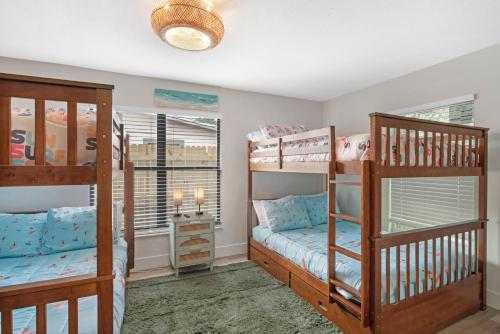 a bedroom with two bunk beds and a window at Lux 6br5ba, Htd Pool, Hot Tub, Game Rm Sleeps 22 in West Bradenton