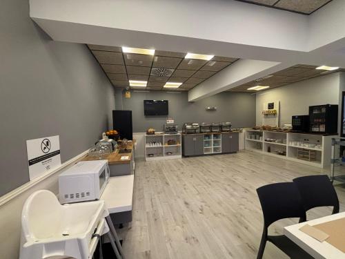 Una sala grande con sala de espera con mesas y sillas. en VTZ Hotel Plaza España, en Zaragoza