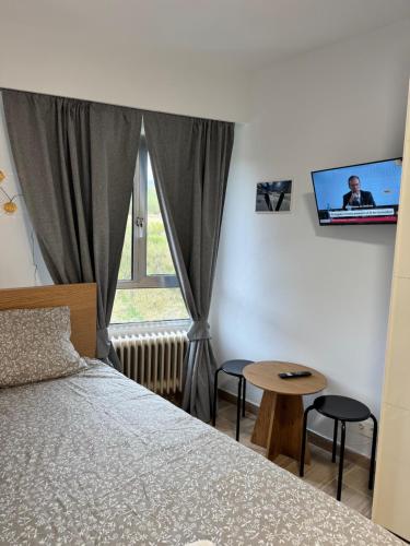 a bedroom with a bed and a window and a table at Precioso apartamento en San Isidro , ski , snow in San Isidro