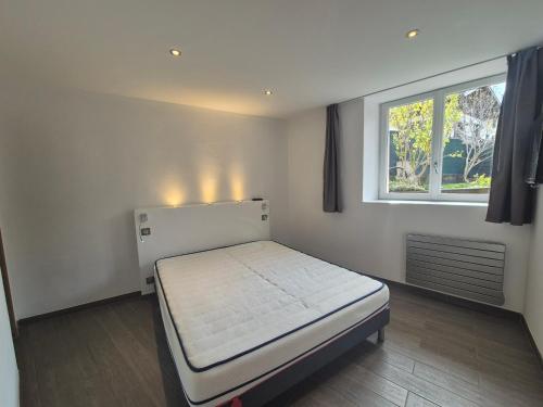 una piccola camera da letto con un letto e una finestra di Charmant 2 pièces avec jardin - Hyper centre BSM a Bourg-Saint-Maurice