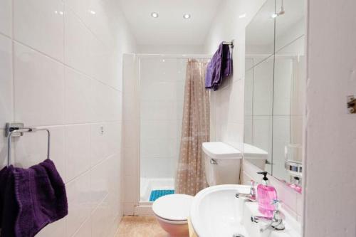 a white bathroom with a sink and a toilet at Edinburgh Central Lauriston Aparthotel in Edinburgh