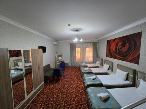a hotel room with four beds and a television at Sarp Hotel in Baku