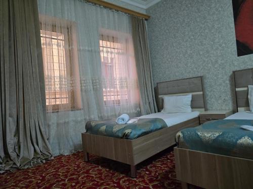 a hotel room with two beds and two windows at Sarp Hotel in Baku