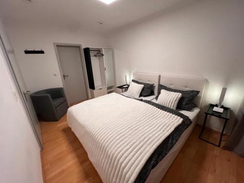 a bedroom with a large white bed and a chair at Rheinstraße 33, Mainz mit Domblick in Mainz