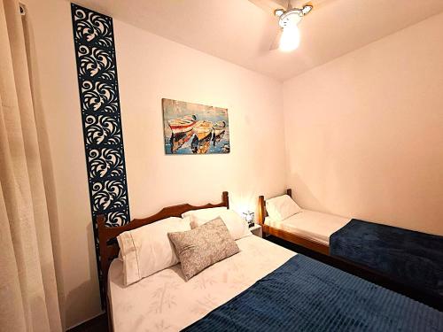 Una cama o camas en una habitación de Pousada Pé na Areia Itanhaém