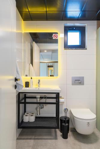 a bathroom with a sink and a toilet and a mirror at Demirel Suites Antalya-Lara Plajlar ve Havalimanına Yakın in Lara
