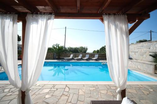 a view of a swimming pool through a window at Cittadella Asprovalta 3BR - private pool in Asprovalta