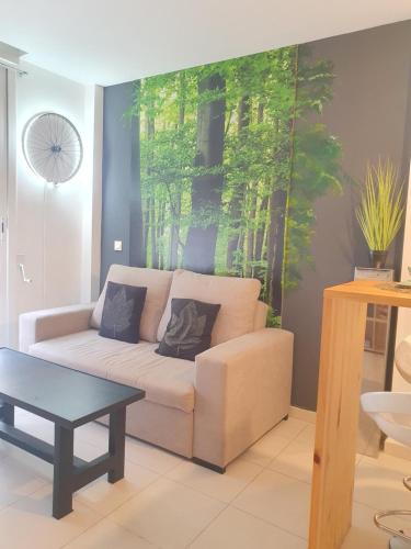 una sala de estar con un sofá con una pintura en la pared en Apartamento San Juan 2, en Murcia