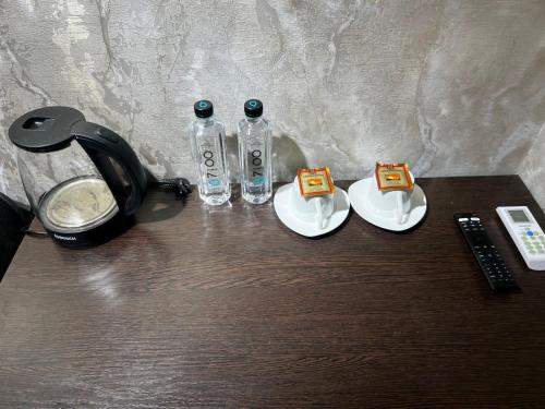 a table with two bottles of water and a telephone at Hotel LION Almaty in Almaty