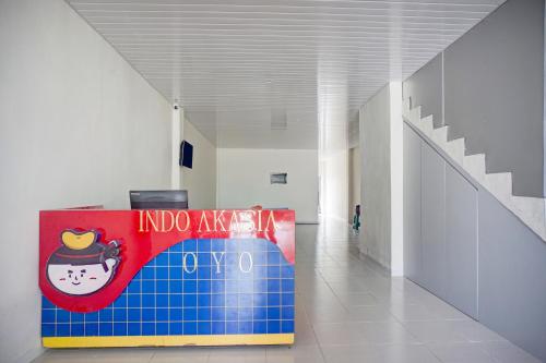een gang met een blauw en rood bord in een gebouw bij OYO 94903 Akasia Guesthouse in Perbaungan