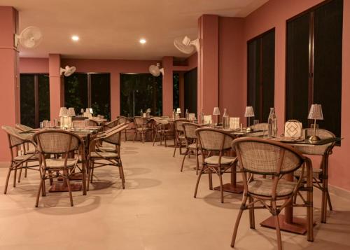 a row of tables and chairs in a room with pink walls at Irroi Kaziranga in Kāziranga
