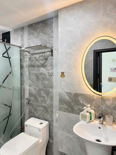 a bathroom with a toilet and a sink and a mirror at Four P Home in Ho Chi Minh City