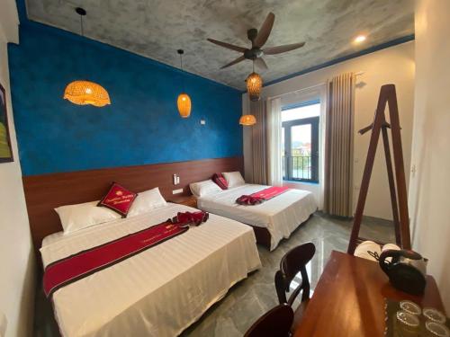 a bedroom with two beds and a ceiling fan at Tam Coc HaVi's Hotel - Restaurant in Văn Lâm