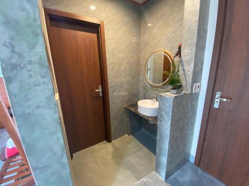 a bathroom with a sink and a mirror at Tam Coc HaVi's Hotel - Restaurant in Văn Lâm