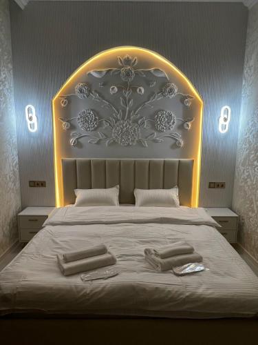 a bedroom with a large bed with two towels on it at Hotel LION Almaty in Almaty