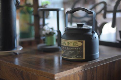 卡埃特Pousada e Restaurante Victórios的一个黑色水罐放在木桌上。