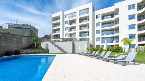 an apartment with a swimming pool and lounge chairs at Casa do Xano I by LovelyStay in Câmara de Lobos