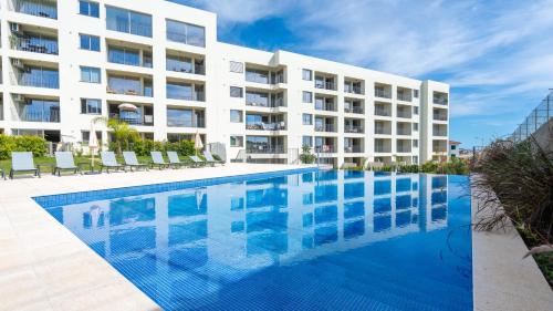 a large white apartment building with a swimming pool at Casa do Xano I by LovelyStay in Câmara de Lobos