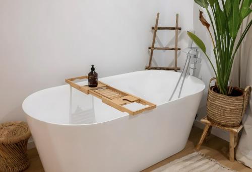 une baignoire avec un plateau en bois dessus dans l'établissement Quinta dos Anjos - Guilhofrei, à Guilhofrei