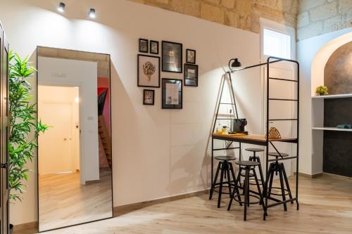 a mirror in a room with a table and stools at Loft Rooms Suite B&B in Santeramo in Colle