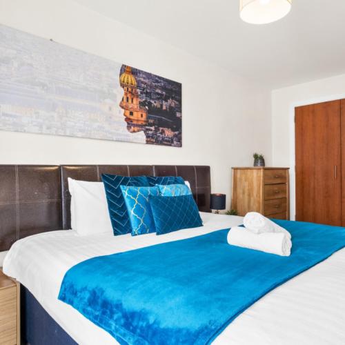 una camera da letto con un letto grande con una coperta blu di Stylish Apartment - Private Parking - Balcony - Chinatown - 49Arc a Birmingham