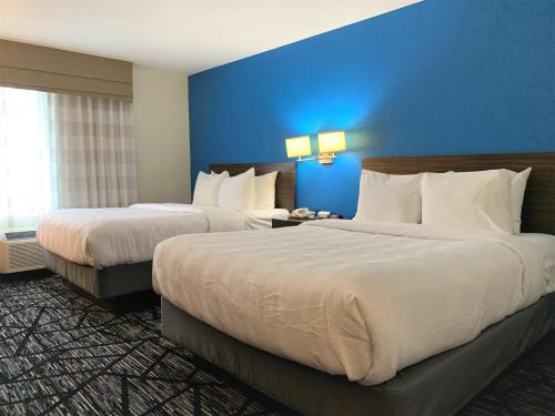 a hotel room with two beds and a blue wall at SureStay by Best Western Cambridge in Cambridge