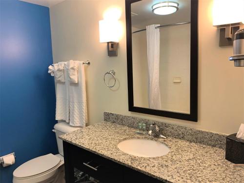 a bathroom with a sink and a toilet and a mirror at SureStay by Best Western Cambridge in Cambridge
