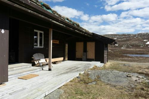 a cabin with a bench on a wooden deck at Renovated Mountain Cabin With Cross Country Trails in Granheim