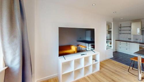 a living room with white walls and a kitchen at Three Bed Flat on Shakespeare St Sleeps up to 6 in Nottingham