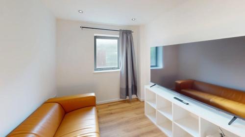 a living room with a leather couch and a window at Three Bed Flat on Shakespeare St Sleeps up to 6 in Nottingham