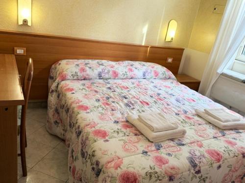 ein Schlafzimmer mit einem Bett mit zwei Handtüchern darauf in der Unterkunft Hotel Bruna in Rom