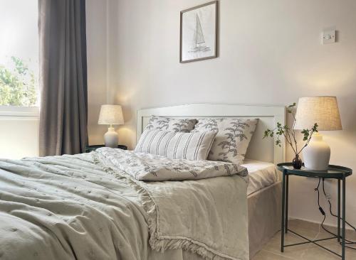 ein weißes Schlafzimmer mit einem großen Bett und einem Fenster in der Unterkunft Luxury 5-Bedroom Villa Sarcon 88 on seaside in Karaoğlanoğlu