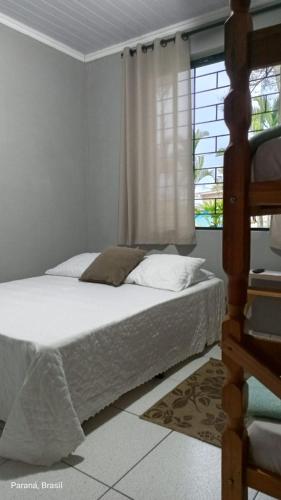 a bedroom with a bed and a window at Pousada Cantinho D´Lilica in Balneário Praia do Leste